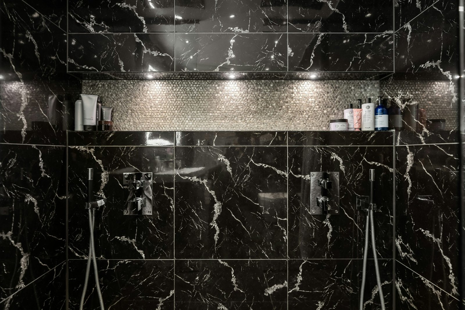 A bathroom with a black and white marble shower