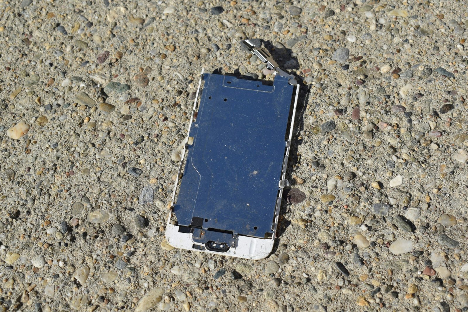 a broken cell phone laying on the ground