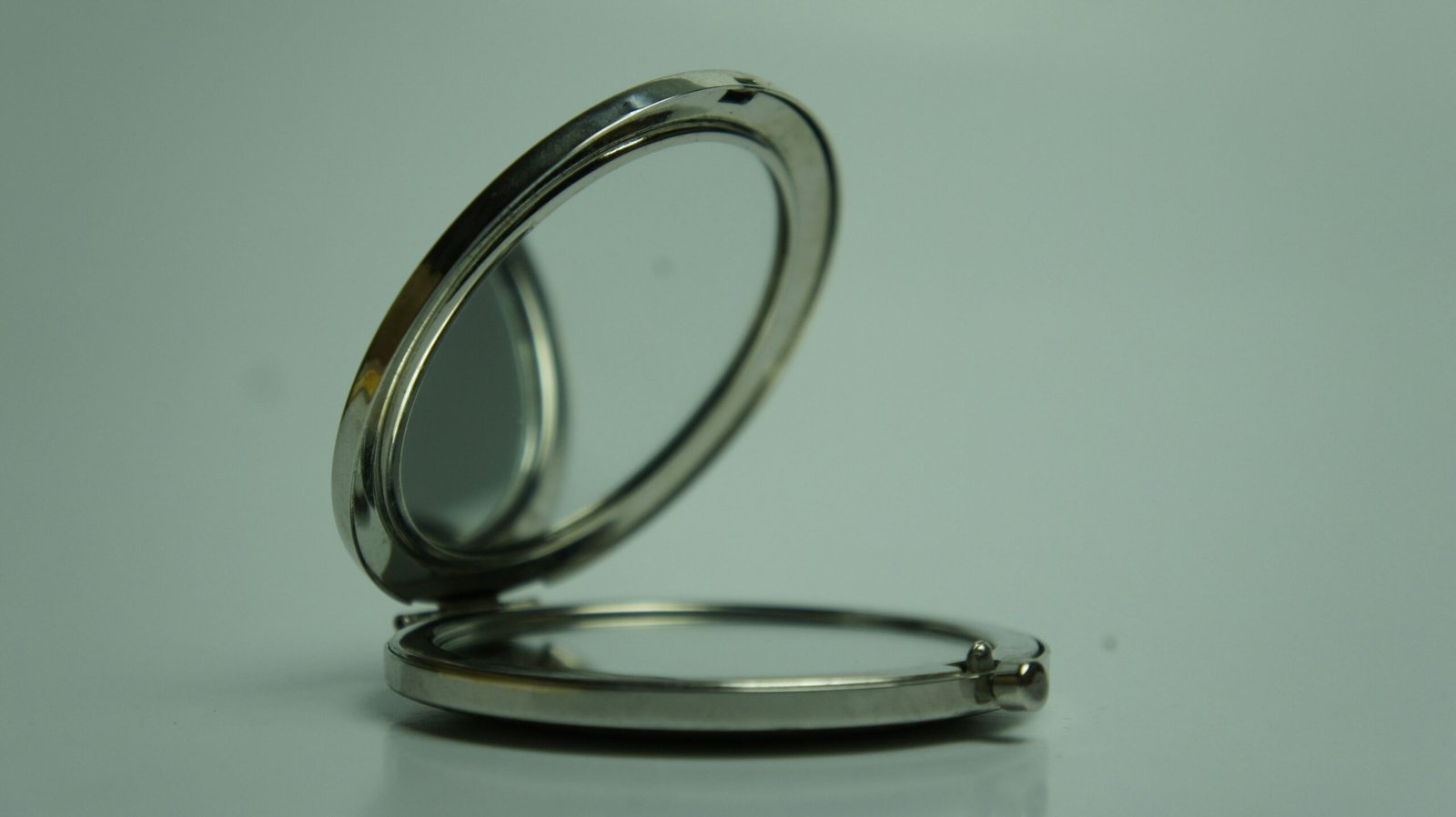 a silver pocket watch sitting on top of a table