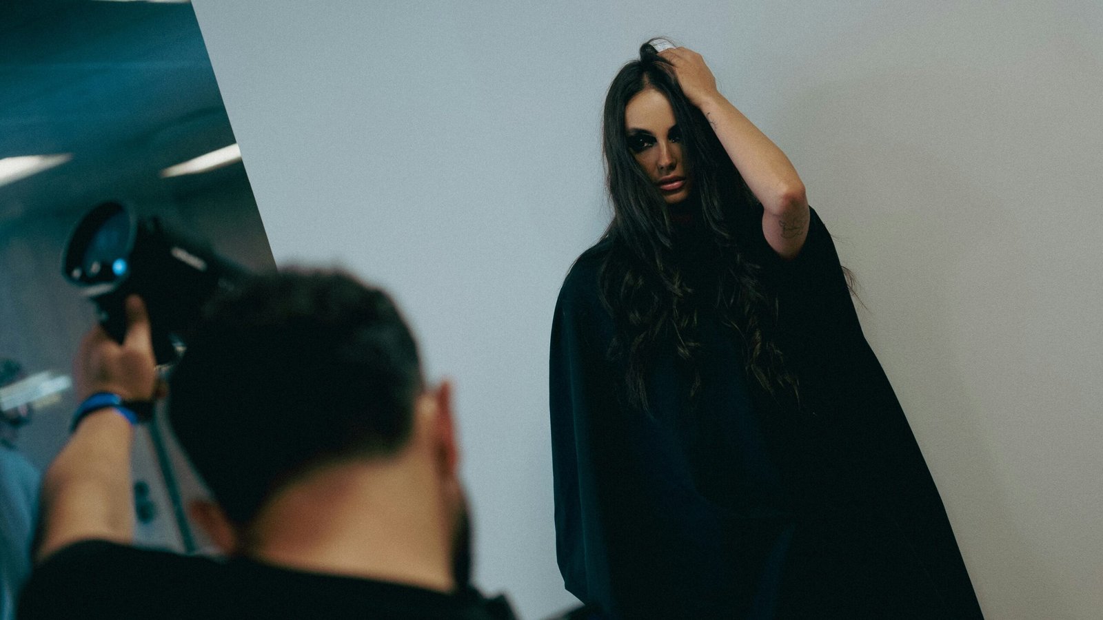 Model posing for photographer with flash