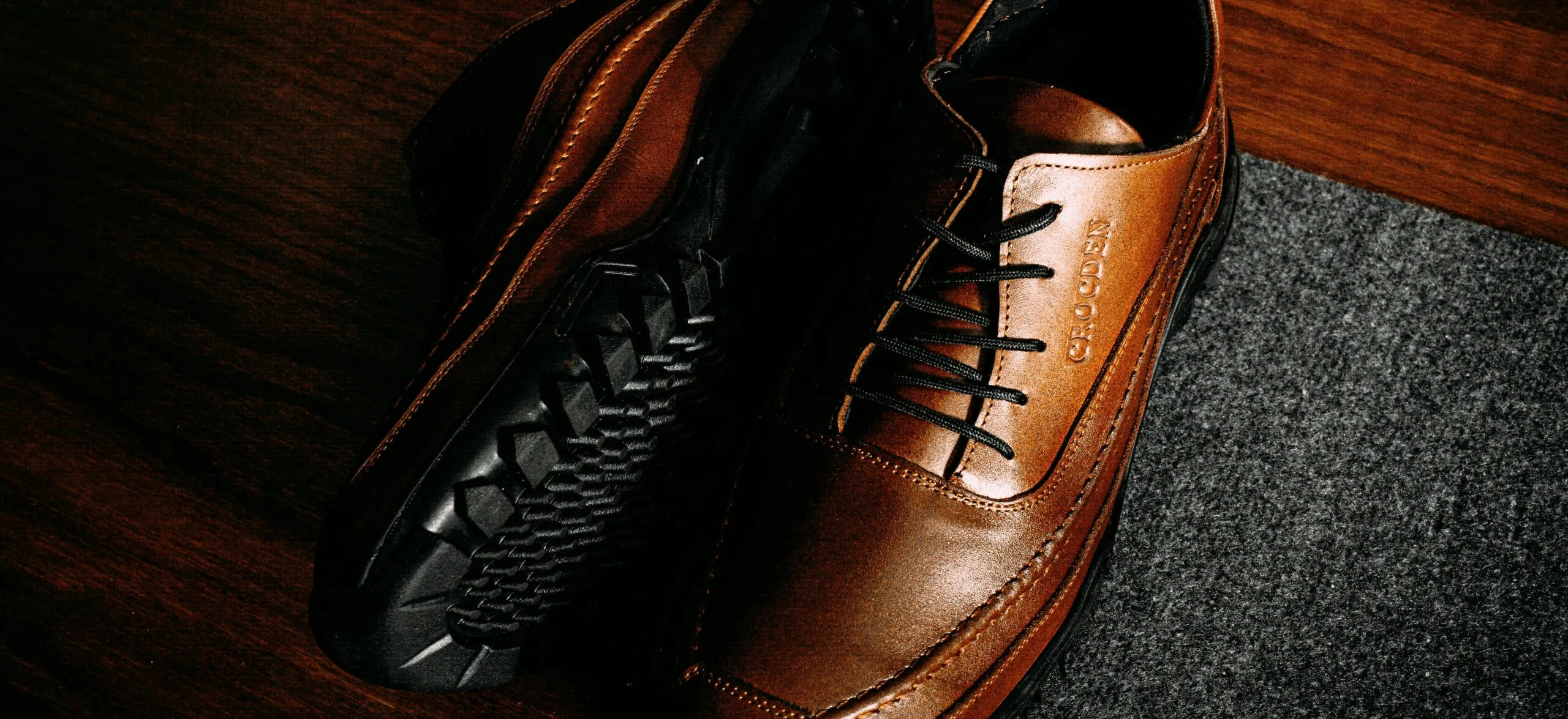 a pair of brown shoes sitting on top of a wooden floor