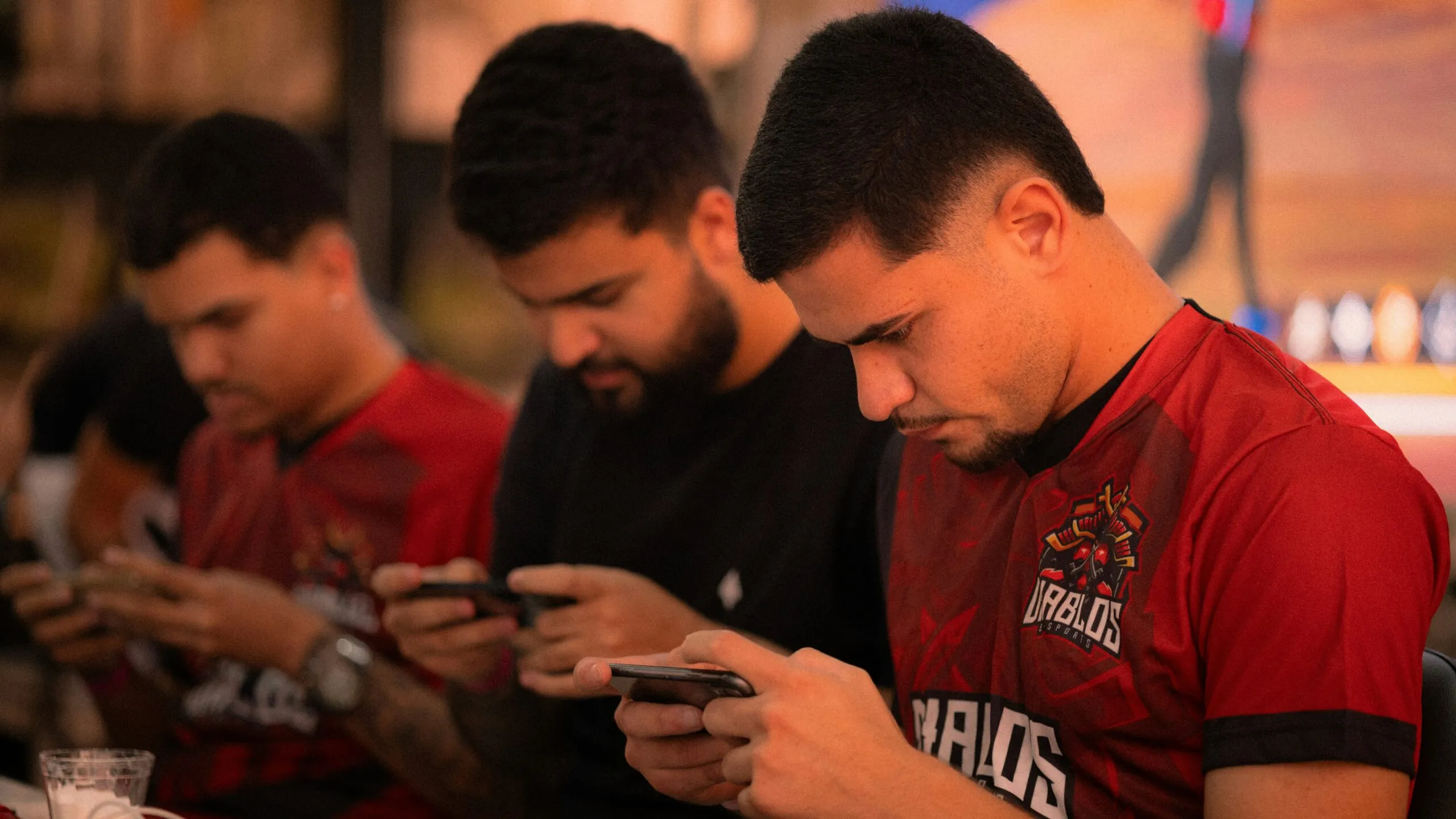 Three men looking down at their phones