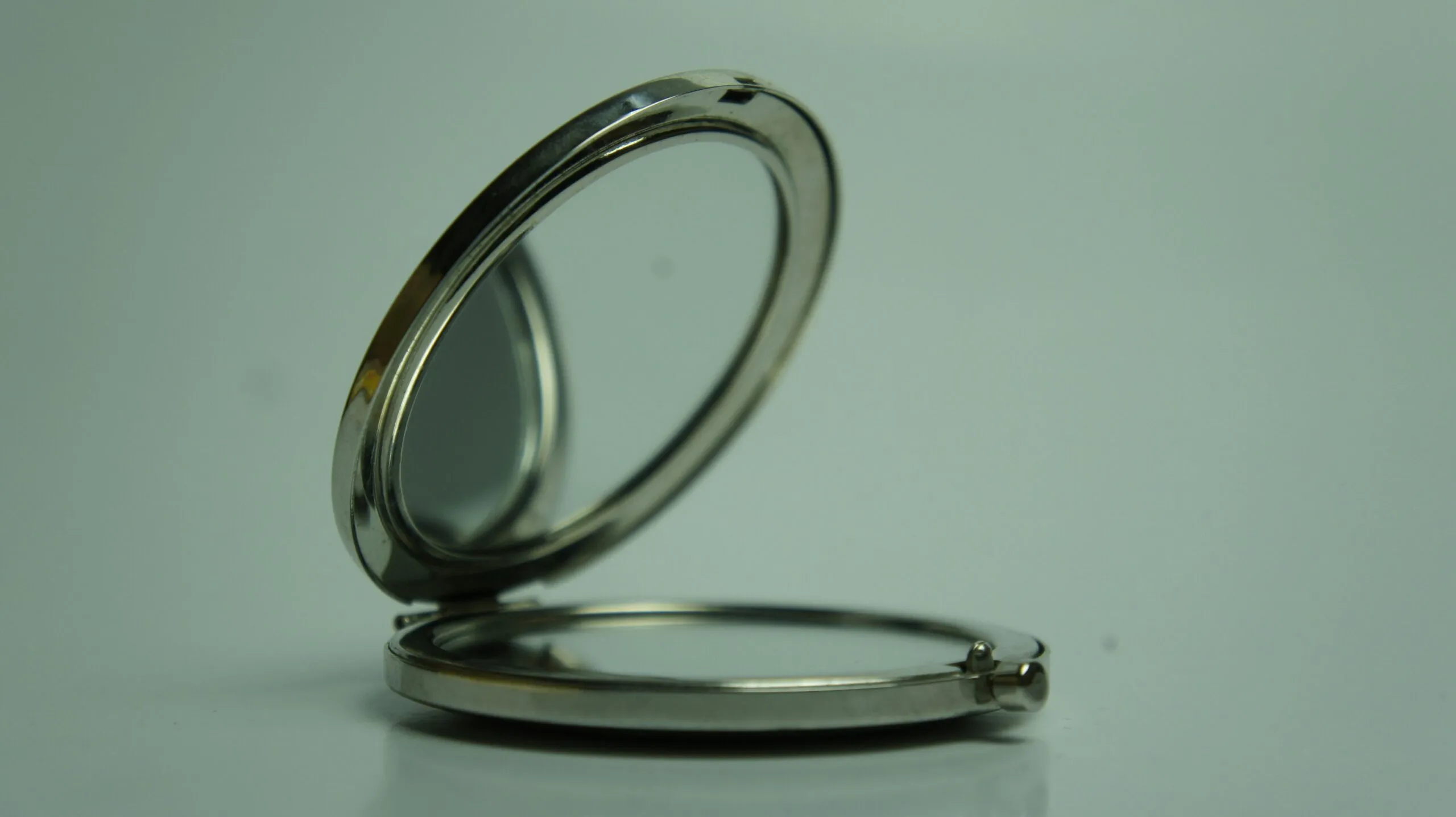 a silver pocket watch sitting on top of a table