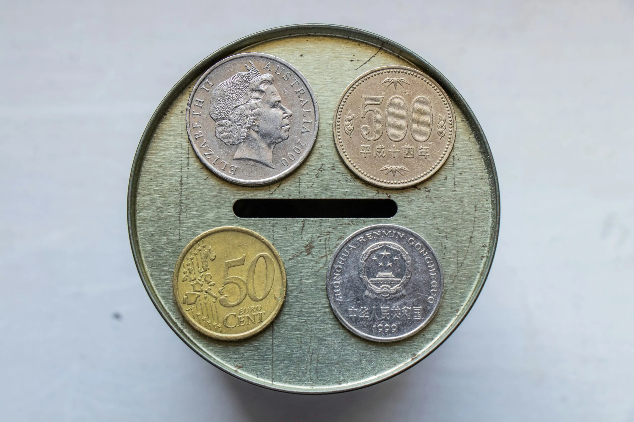 gold round coin on white surface