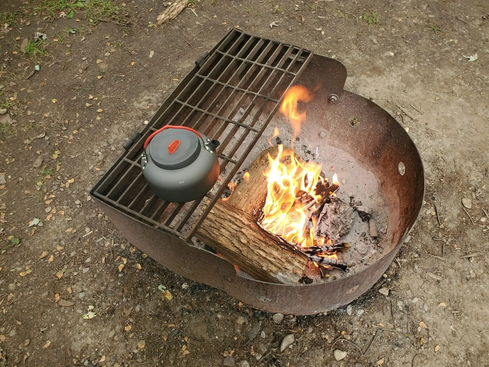 a fire pit with a pot and a pot on it
