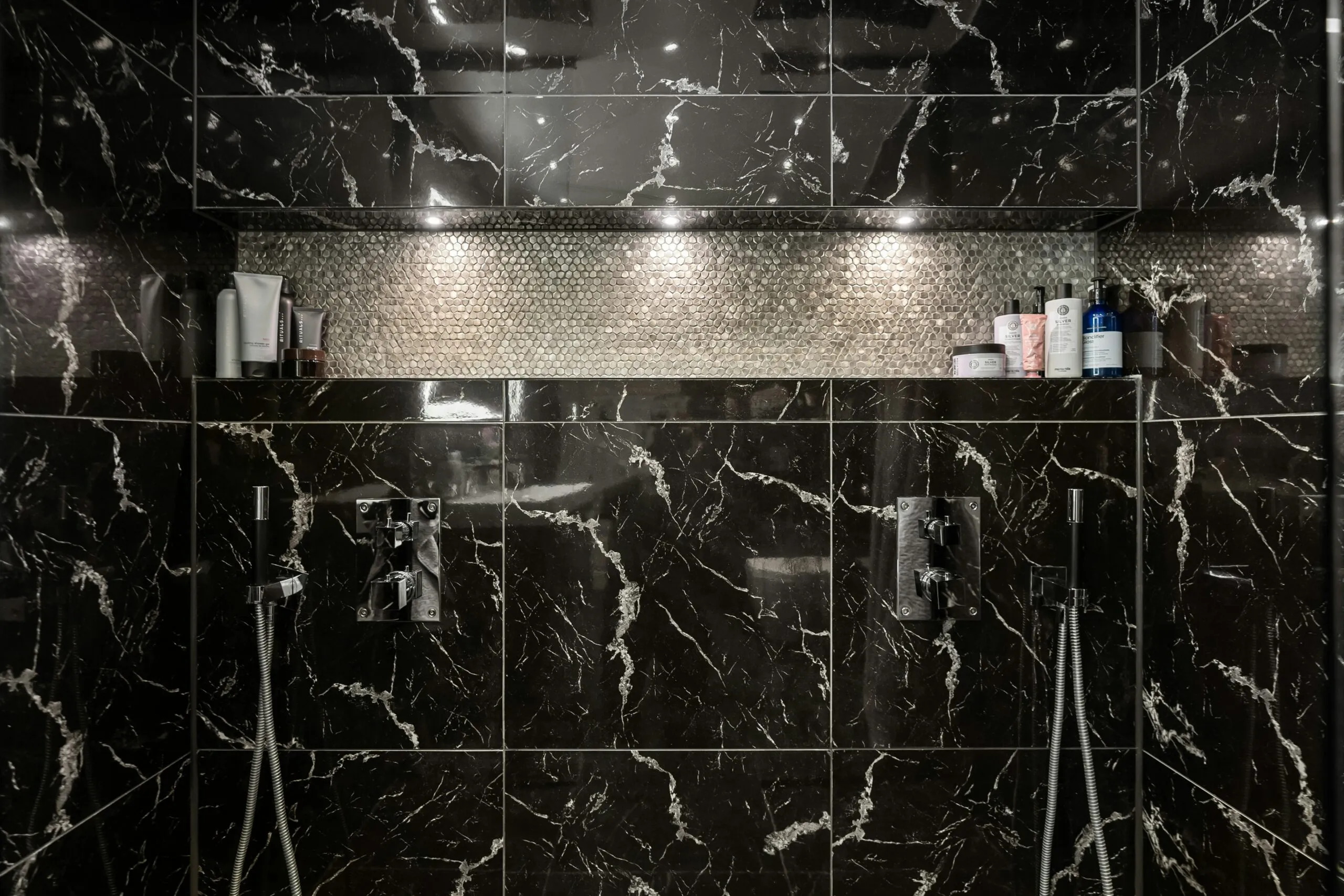 A bathroom with a black and white marble shower