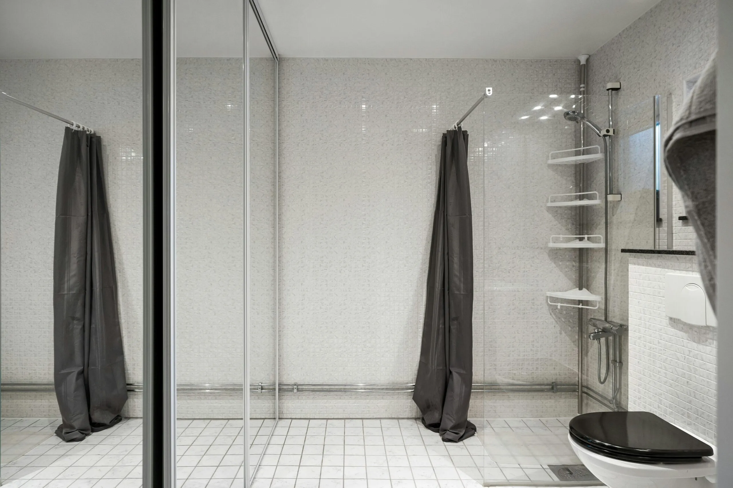 A bathroom with a toilet and a shower