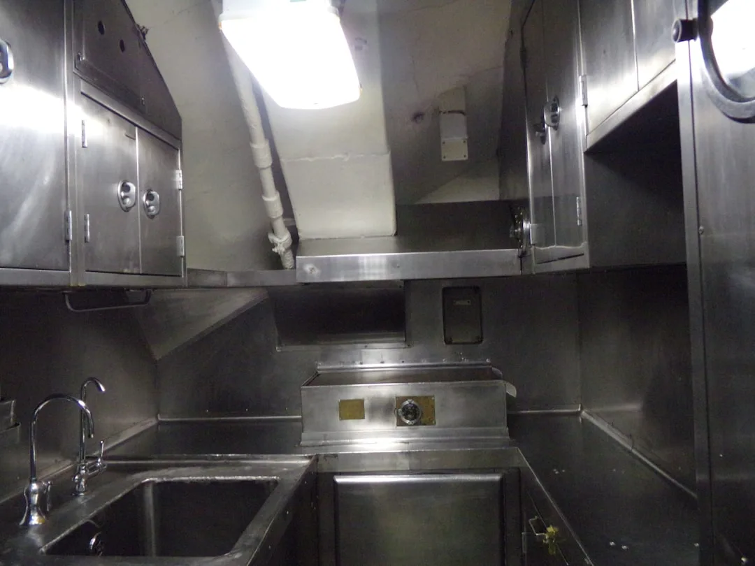 a stainless steel kitchen with a sink and a window