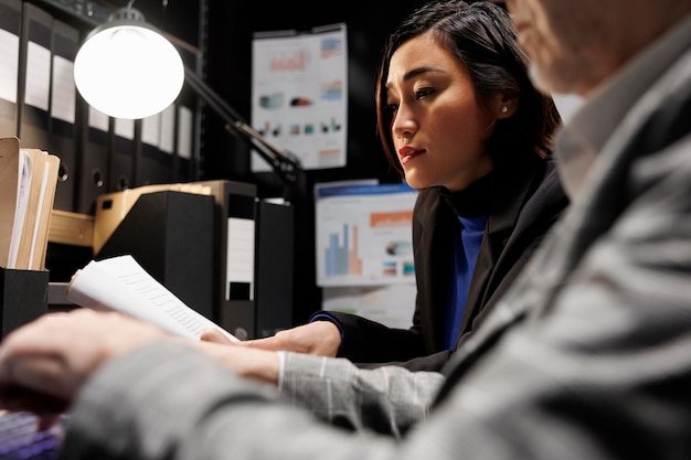 Accounting business executives coworkers imputing bookkeeping analytics data on laptop. Teamworking elderly businessman and asian collegue in administrative archival depository storage office