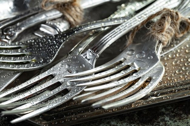Antique silver cutlery on a dark background in a composition on a table