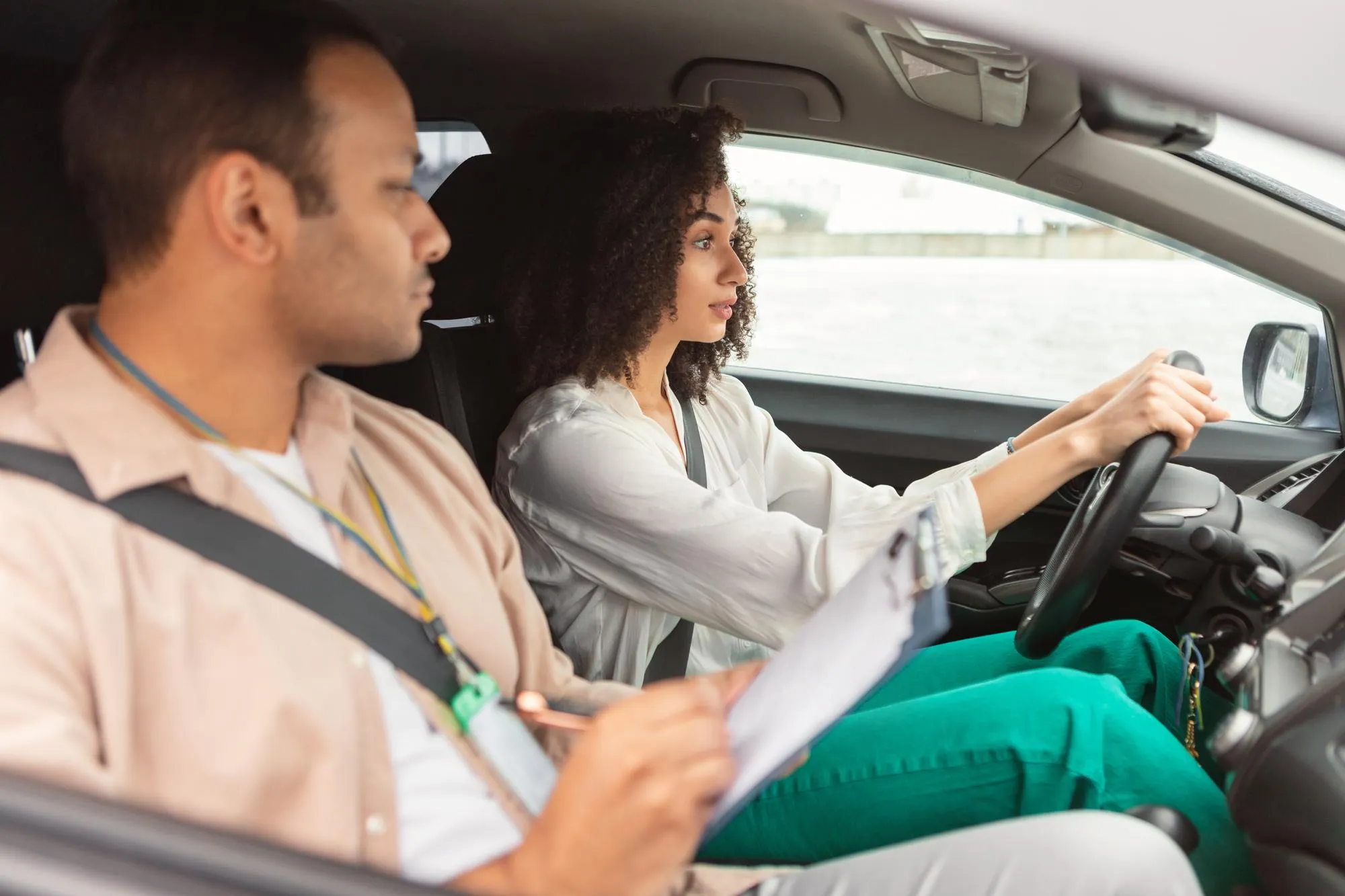 Arabic instructor man conducting driving test for novice driver lady