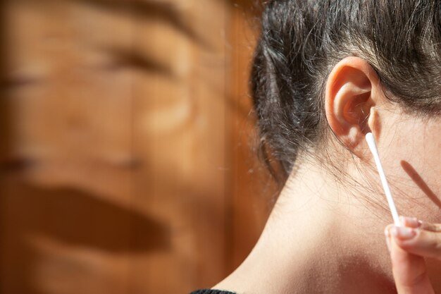 Caucasian young woman holding cotton bud