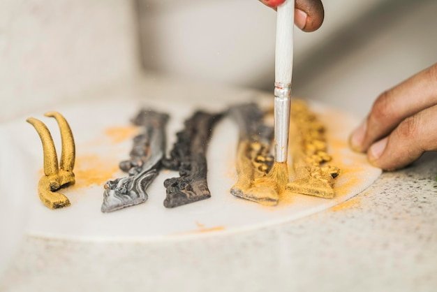 Chef using a brush to decorate some elements to garnish of a cake