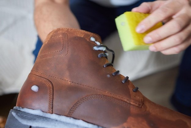 Cleaning suede sneakers A worker in a shoe workshop cleans a pile of shoes