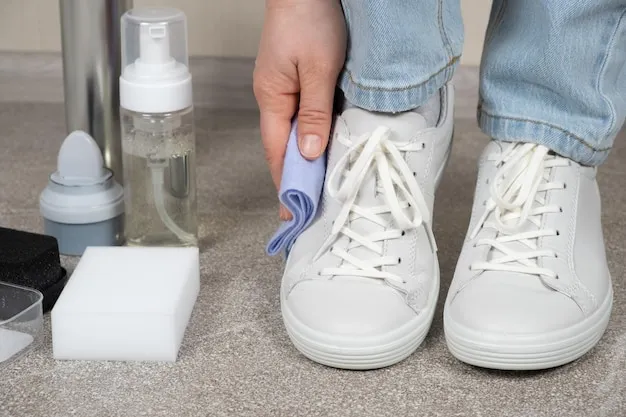 Cleaning white shoes caring for sneakers A woman wipes her leather shoes with a wet cloth from dust and dirt