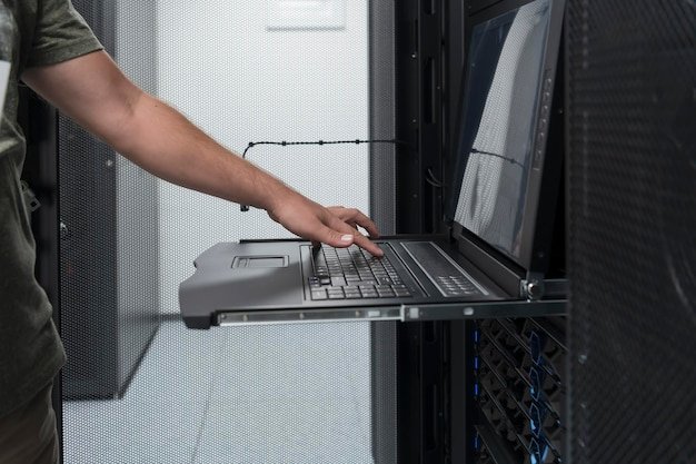 Close up on Data Center Engineer hands Using keyboard on a supercomputer Server Room Specialist Facility with Male System Administrator Working with Data Protection Network for Cyber Security