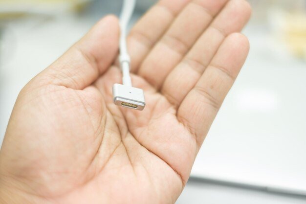 Close-up of hand holding electric plug