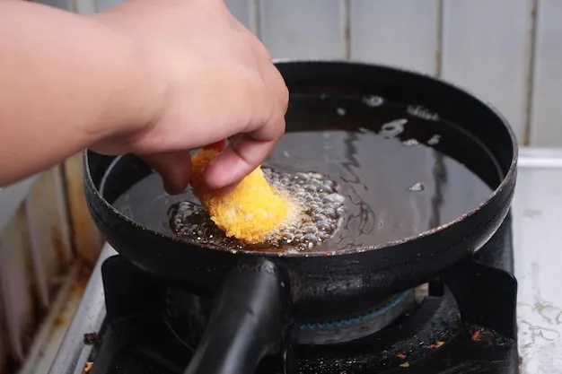 Close up image of chef hand putting chicken nuggets tempura in to hot oil pan for deep fry cooking