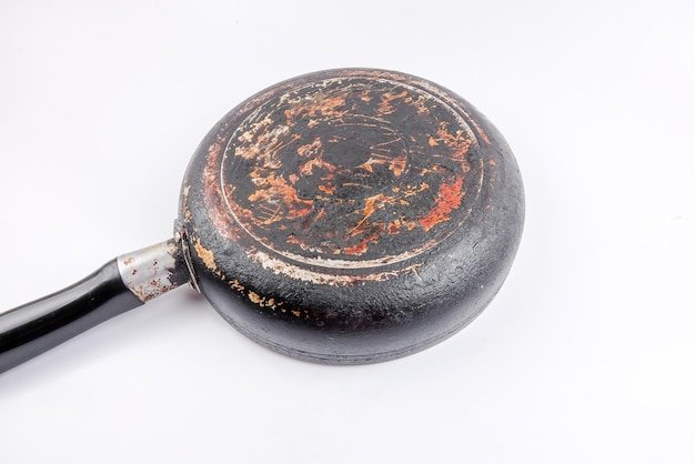 Close-up of old cooking pan over white background