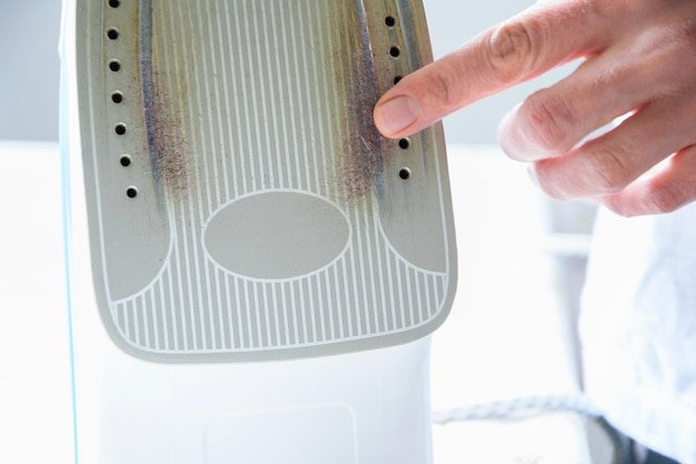 Close-up of woman touching iron