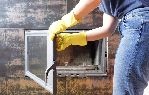 Close up of young woman in jeans yellow gloves is cleaning the fireplace Modern fireplace with glass