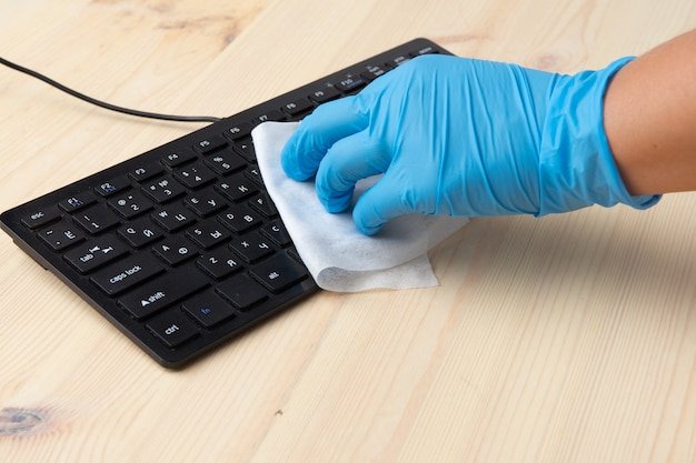 Covid-19 sanitizing office space wiping corona virus cleaning and disinfection of your workspace. Disinfecting wipes to wipe surface of desk, keyboard, mouse.