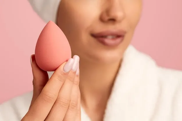 Crop woman showing pink makeup blender
