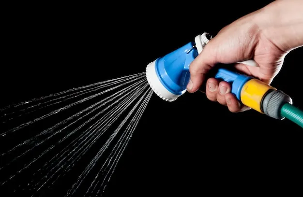 Cropped hand of person holding garden hose against black background