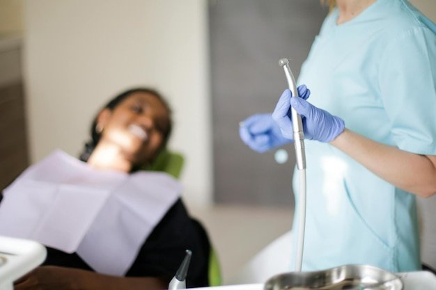 Dentist in dental office talking with female patient and preparing for treatment