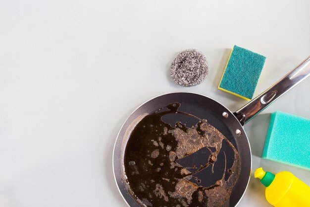 Directly above shot of cooking pan and cleaning sponge on table