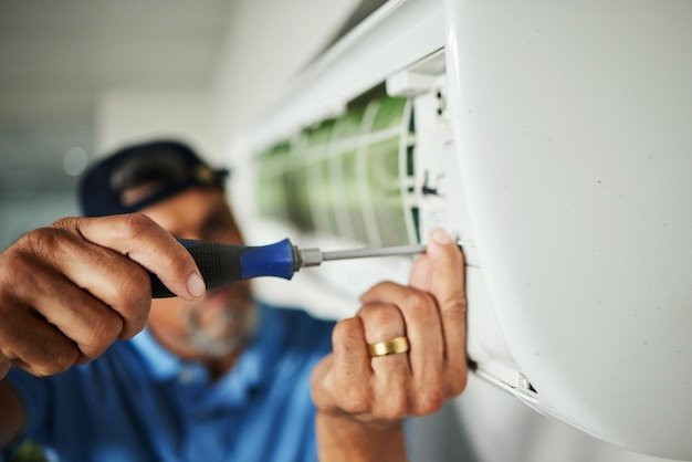 Electrician hands and air conditioning with man and screwdriver for maintenance ventilation or power Engineering electricity and inspection with closeup of technician for ac repair and contractor