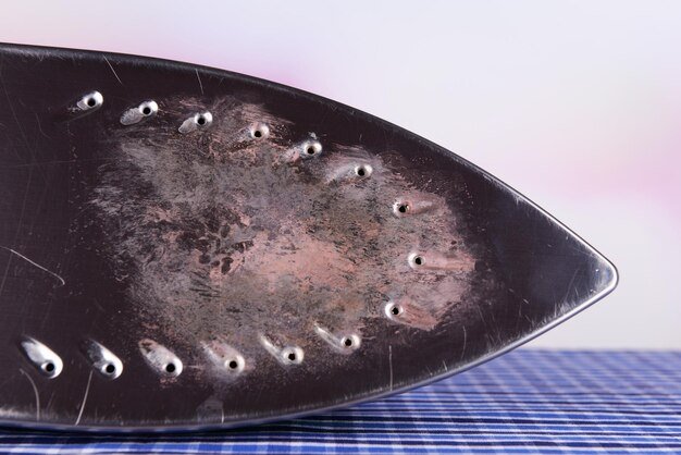 Flat iron with burnt mark on table on bright background