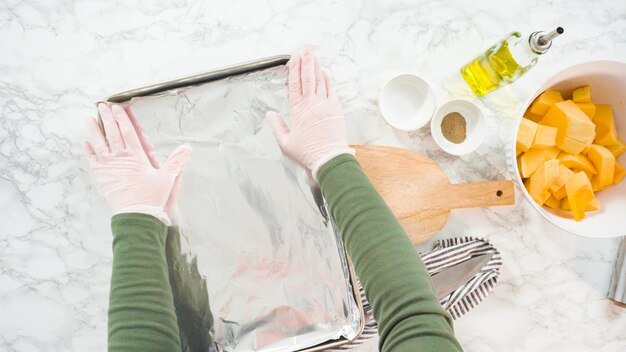 Flat lay. Cutting butternut squash on a wood cutting board.