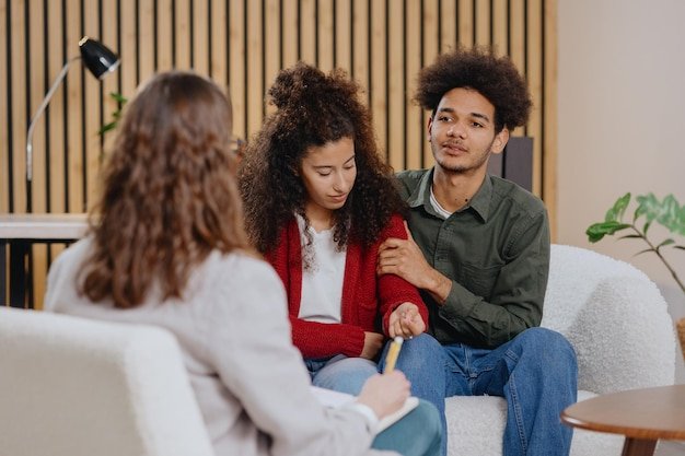 Friends sitting on sofa at home