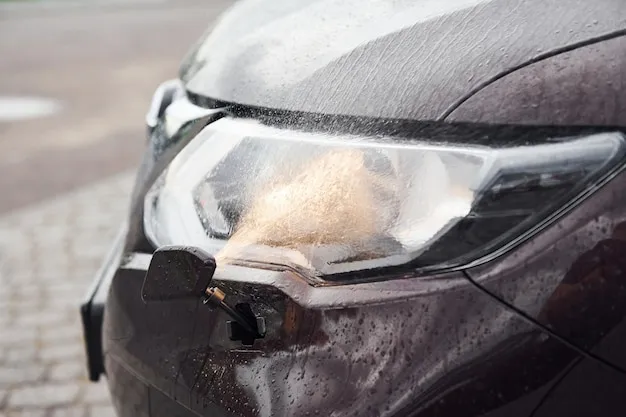 Front particle view of black modern automobile with headlights on