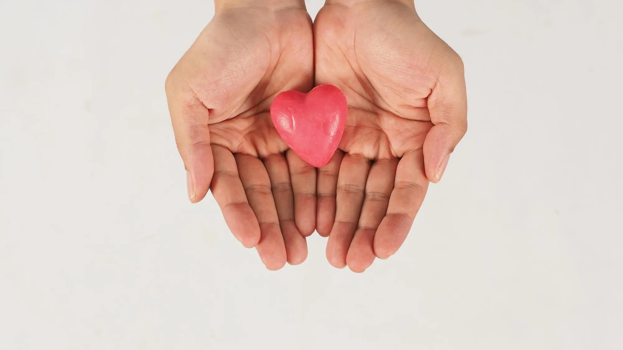 Hands and pink soap on white background Studio shot