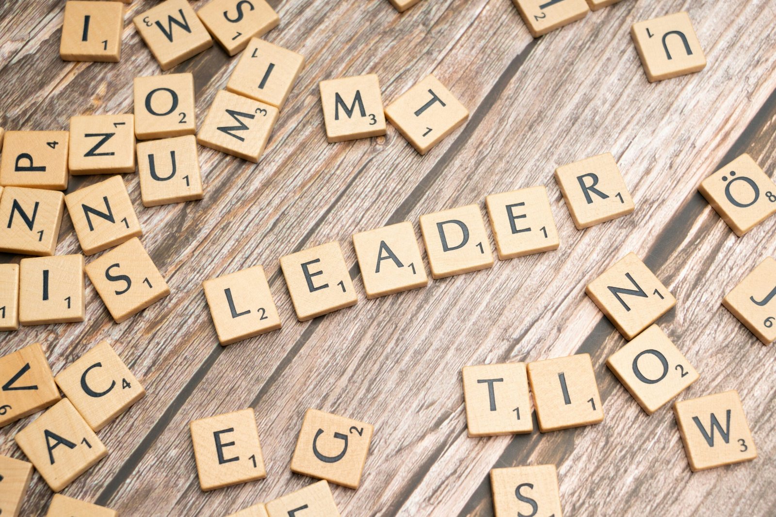 scrabble tiles spelling out the word leader in a word