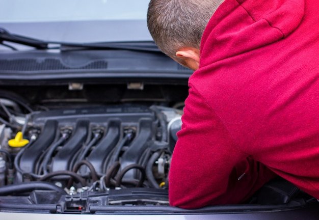A man repairs a car