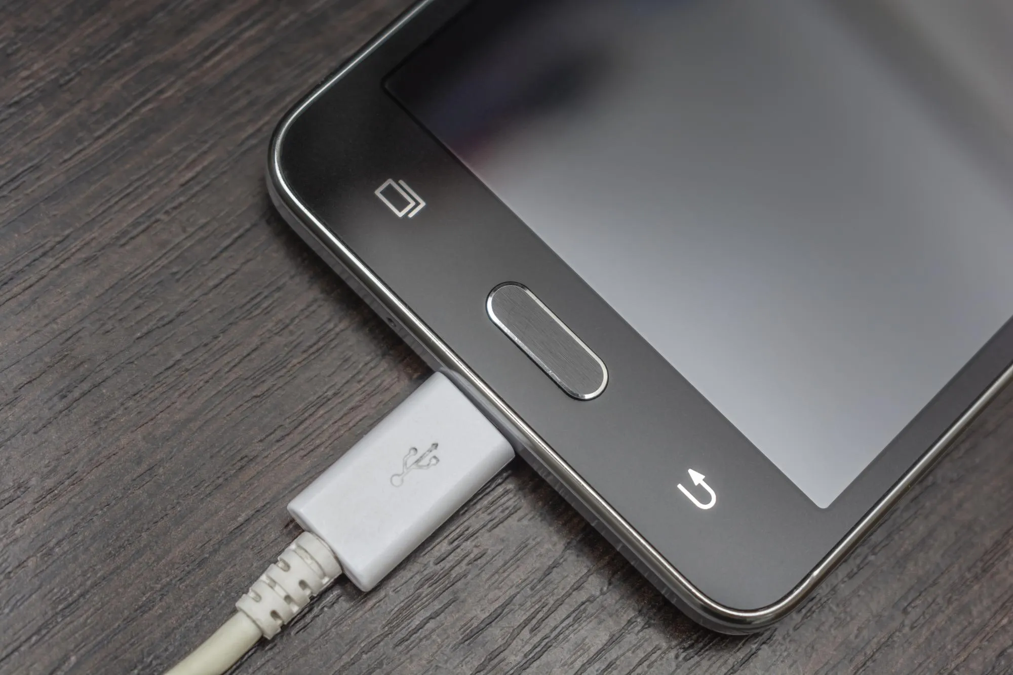 Mobile smart phones charging on wooden desk