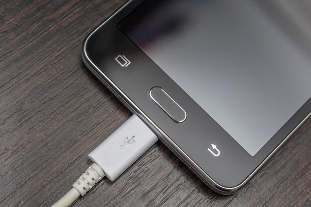 Mobile smart phones charging on wooden desk