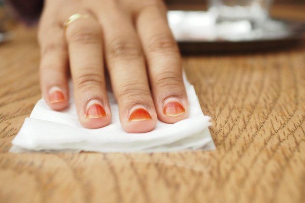 Person hand cleaning table with cloth