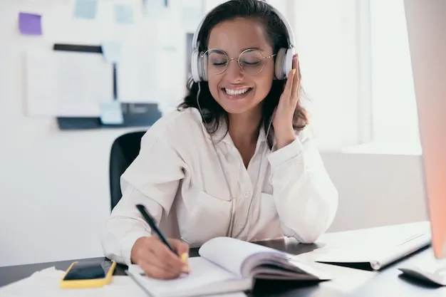 Pretty young caucasian woman in headphones dancing to music and writing lists in her planner