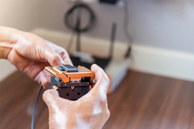 Selective focus of internet technicians man are cutting fiber optic cables with cutting tool prepare for splicing, Home IT network