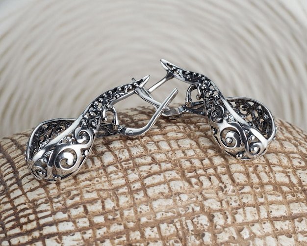 A set of jewelry from a ring and earrings with zircon on an artistic curly background