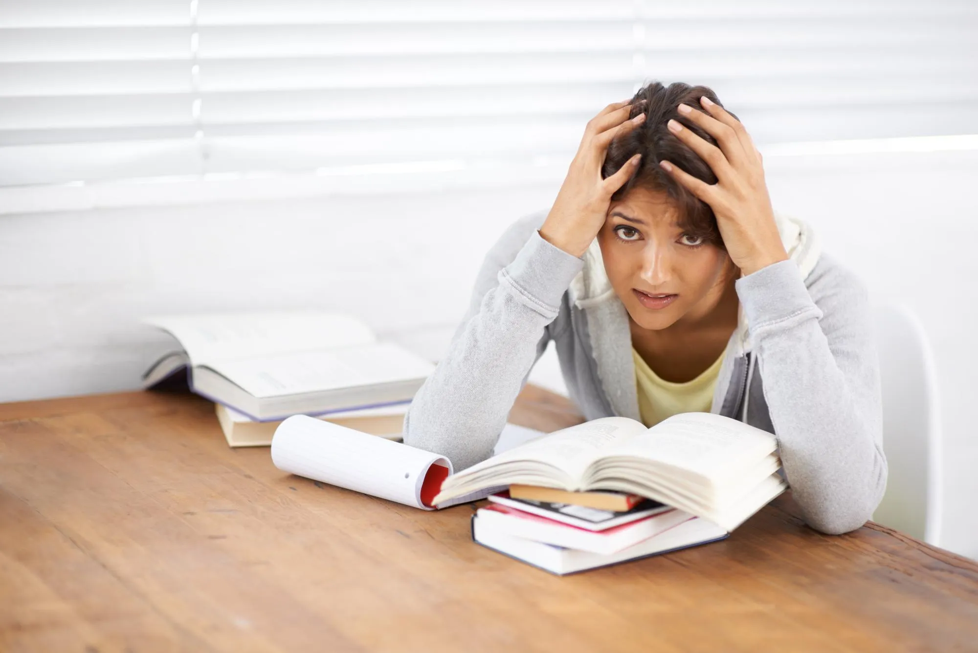 Student woman and frustrated with studying or books for knowledge and education with notes in bedroom Young person girl and portrait at desk or confused for scholarship project and assessment