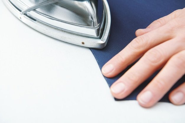 Tailor ironing foldes in fabric Clothes sewing Clothing repair Tailoring Close up view