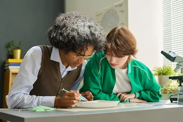 Two teenage intercultural students of highschool doing dissection of frog