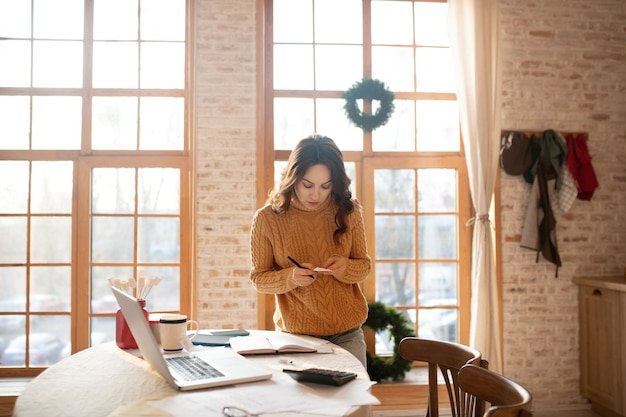 Woman in sweater working on a laptop