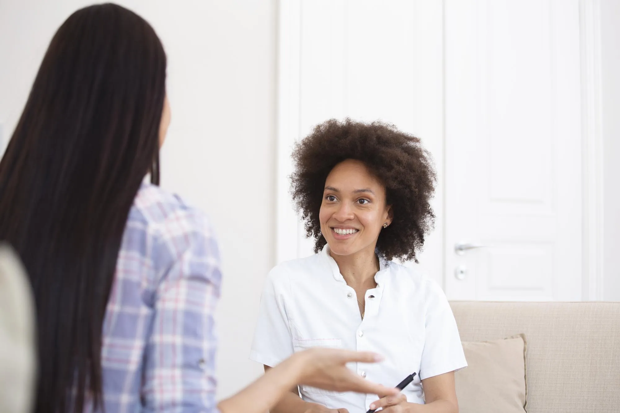 Woman at therapy session Attentive psychologist Attentive psychologist holding pencil in her hands making written notes while listening to her client