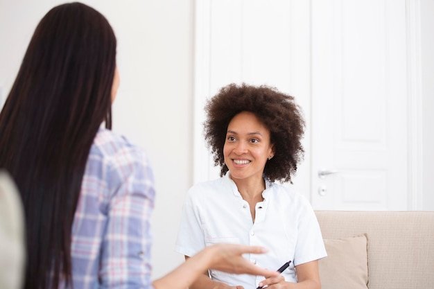 Woman at therapy session Attentive psychologist Attentive psychologist holding pencil in her hands making written notes while listening to her client
